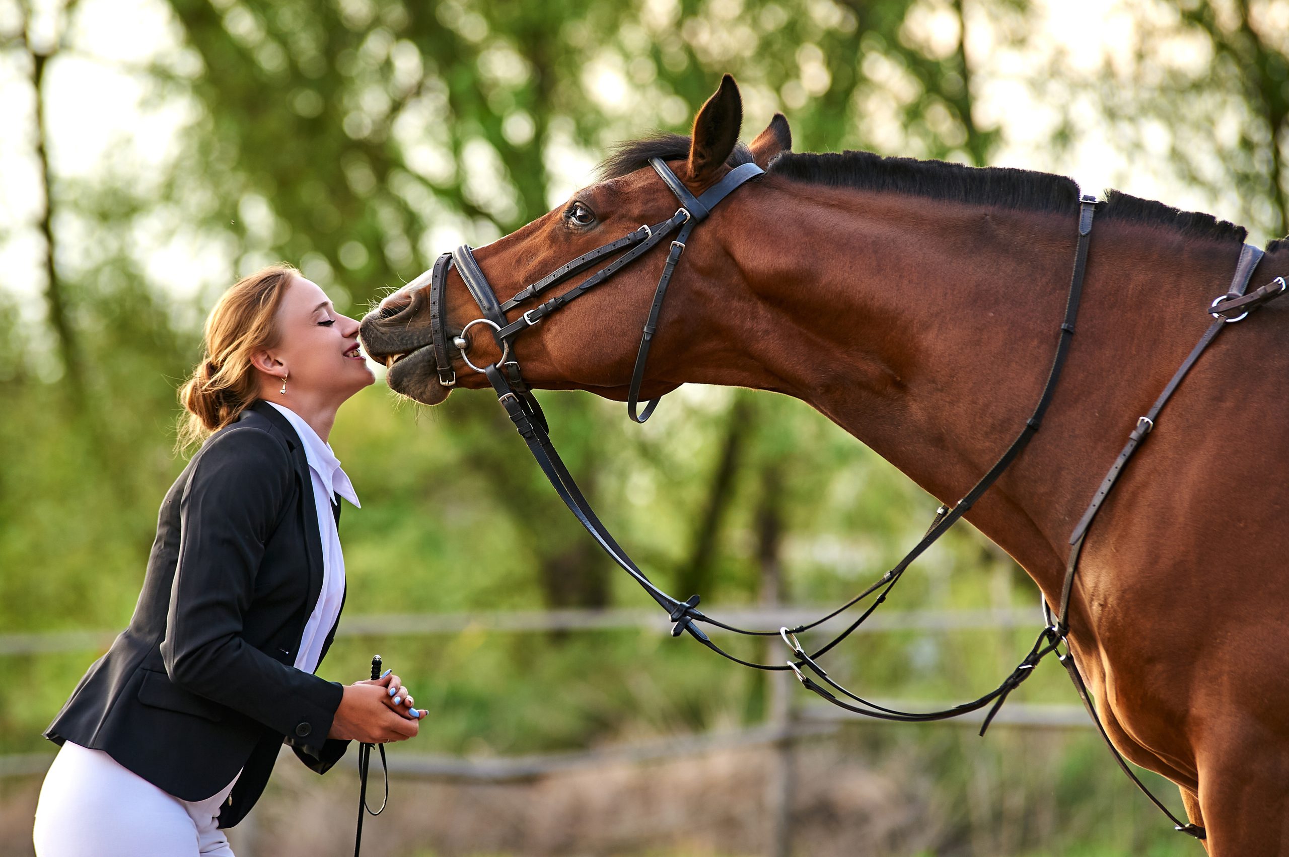 horse rider girl and horse on a farm. horse kisses a girl.